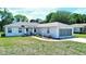 Inviting home featuring a screened garage, well-kept lawn, and a garden near the walkway to the front door at 4998 Nw 30Th Pl, Ocala, FL 34482