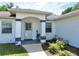 Close-up view of the front entry with white columns, decorative plants, and ADT security system at 4998 Nw 30Th Pl, Ocala, FL 34482