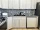 Modern kitchen with stainless steel appliances, light gray cabinets, and dark granite countertops at 4998 Nw 30Th Pl, Ocala, FL 34482