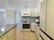 Open-concept kitchen with stainless steel appliances, light gray cabinets, and mosaic tile backsplash at 4998 Nw 30Th Pl, Ocala, FL 34482