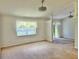 Bright living room with carpet, white walls and trim, and a large window for natural light at 4998 Nw 30Th Pl, Ocala, FL 34482