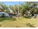 Backyard view of home with screened porch and mature trees at 10060 Se 106Th Ln, Belleview, FL 34420