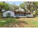 Exterior of home with a screened porch and shady backyard at 10060 Se 106Th Ln, Belleview, FL 34420