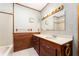 Bathroom with tub, neutral walls, and wood cabinets with a sink at 10060 Se 106Th Ln, Belleview, FL 34420