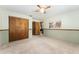 Bedroom featuring carpeted floor, ceiling fan, closet, and half wall paneling at 10060 Se 106Th Ln, Belleview, FL 34420