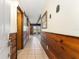Hallway featuring wood paneling, tiled floors, and a view of the outdoor space through French doors at 10060 Se 106Th Ln, Belleview, FL 34420