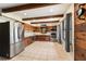 Bright kitchen featuring wooden cabinets, stainless steel appliances, tile floors, and exposed beam ceiling at 10060 Se 106Th Ln, Belleview, FL 34420