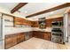 Well-equipped kitchen boasting wood cabinets, stainless steel appliances, tile floors, and warm natural light at 10060 Se 106Th Ln, Belleview, FL 34420
