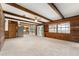 Expansive living room featuring exposed wood beams, wood paneled walls, and natural light from the surrounding outdoor space at 10060 Se 106Th Ln, Belleview, FL 34420