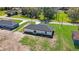 Aerial view of a home with a dark roof, lush green lawn and partial view of the street at 1062 Nw 69Th St, Ocala, FL 34474