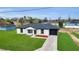 Inviting one-story home showcasing a long driveway, lush green lawn, and a sleek, dark roof at 1062 Nw 69Th St, Ocala, FL 34474