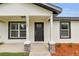 Stylish front porch featuring stone column bases, contrasting trim, and freshly landscaped accents at 1062 Nw 69Th St, Ocala, FL 34474