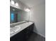 Bathroom featuring double sink vanity with granite countertop and dark wood cabinets at 12864 Sw 40 Ter, Ocala, FL 34473