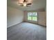 Bright bedroom features neutral carpet, ceiling fan, and a window offering backyard views at 12864 Sw 40 Ter, Ocala, FL 34473