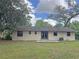 View of the rear exterior, featuring a grassy backyard and concrete patio at 1400 Ne 54Th St, Ocala, FL 34479