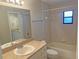 Inviting bathroom with a shower-tub combo, neutral tile, and a vanity with great lighting at 1400 Ne 54Th St, Ocala, FL 34479