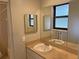 Well-lit bathroom featuring a single sink vanity, a large mirror, and a window at 1400 Ne 54Th St, Ocala, FL 34479