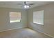 This bedroom is carpeted and has two windows, and a ceiling fan with lights at 1400 Ne 54Th St, Ocala, FL 34479