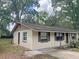 Single-story home with tan siding and brown trim, surrounded by mature trees at 1400 Ne 54Th St, Ocala, FL 34479