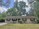 Charming single-story home with a well-maintained lawn and mature trees providing shade at 1400 Ne 54Th St, Ocala, FL 34479