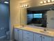 Bathroom features a double sink vanity with a large mirror and tile shower at 16331 Se 81St Ct, Summerfield, FL 34491
