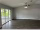 Bright living room featuring wood-look floors, ceiling fan, and sliding glass door at 16331 Se 81St Ct, Summerfield, FL 34491