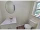 Compact bathroom includes a toilet, vanity sink, and a window providing natural light at 23177 Sw Beach Blvd, Dunnellon, FL 34431