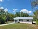 Beautiful shot of a single-story house with a metal roof, tidy lawn, and a newly painted driveway at 23177 Sw Beach Blvd, Dunnellon, FL 34431