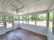 Sunroom with stylish wood-look floors, multiple windows, and a ceiling fan, creating a tranquil and inviting space at 23177 Sw Beach Blvd, Dunnellon, FL 34431