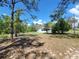 Expansive front yard, ideal for outdoor activities, framed by mature trees under a bright sky at 23177 Sw Beach Blvd, Dunnellon, FL 34431