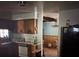 This kitchen has older cabinets and a view into another room at 2323 Sw 3Rd St, Ocala, FL 34471