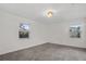 Well-lit carpeted bedroom with two windows and fresh white paint throughout at 4246 Ne 32Nd Cir, Ocala, FL 34479