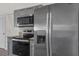 Modern kitchen featuring stainless steel appliances and gray cabinets with granite countertops at 4246 Ne 32Nd Cir, Ocala, FL 34479
