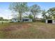 View of the house from a spacious yard that features a utility shed, and screened in back patio at 44 Pecan Run Dr, Ocala, FL 34472