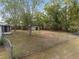 Spacious backyard features a chain-link fence, mature trees, and an outbuilding for extra storage at 44 Pecan Run Dr, Ocala, FL 34472