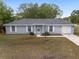 Inviting one-story home featuring neutral siding, a gray roof, and a well-kept front yard at 44 Pecan Run Dr, Ocala, FL 34472