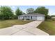 Exterior view of a single-story home featuring a long driveway and attached garage at 44 Pecan Run Dr, Ocala, FL 34472