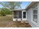 Exterior view of a screened-in patio with a door and a small air conditioner, connecting the home to the yard at 44 Pecan Run Dr, Ocala, FL 34472