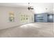 Bright, open living room with neutral carpet, high ceiling, and sliding glass doors to the backyard at 4780 Sw 103Rd Street Rd, Ocala, FL 34476