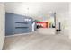 Open living area with neutral walls, carpet floors, high ceiling, and views of the kitchen at 4780 Sw 103Rd Street Rd, Ocala, FL 34476