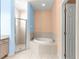 Clean main bathroom offers tiled shower, soaking tub, and double door entrance at 4780 Sw 103Rd Street Rd, Ocala, FL 34476