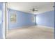 Bright main bedroom featuring neutral carpet, ceiling fan, and windows letting in lots of natural light at 4780 Sw 103Rd Street Rd, Ocala, FL 34476