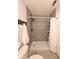 Bathroom with a tiled shower, shelves, white shower curtain and grey wood-like flooring at 4785 Ne 28Th Ter, Ocala, FL 34479