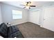 Carpeted bedroom with fan, window, closet, futon, table and lamp at 4785 Ne 28Th Ter, Ocala, FL 34479