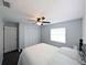 Carpeted bedroom featuring a ceiling fan, window, and double door closet at 4785 Ne 28Th Ter, Ocala, FL 34479