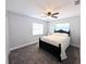 Carpeted bedroom featuring a ceiling fan, two windows, and a black framed bed with white bedding at 4785 Ne 28Th Ter, Ocala, FL 34479