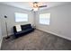 Carpeted bedroom with grey walls, two windows and a sofa at 4785 Ne 28Th Ter, Ocala, FL 34479