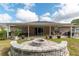 A backyard with a fire pit surrounded by a brick patio and a covered patio at 5026 Sw 128Th St, Ocala, FL 34473