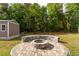 Landscaped backyard featuring a brick fire pit surrounded by trees at 5026 Sw 128Th St, Ocala, FL 34473