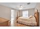 Bedroom featuring hardwood floors, natural lighting, and an ensuite bathroom at 5026 Sw 128Th St, Ocala, FL 34473